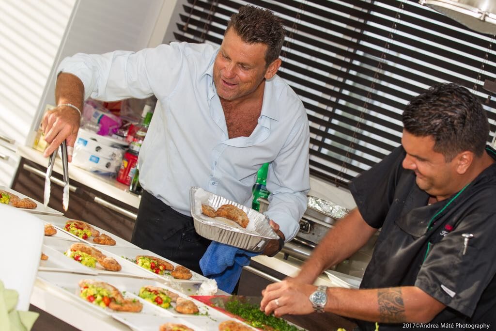 Two chefs plating pastechi with avocado salad in a bright kitchen